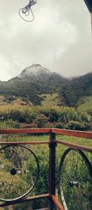 a bike leaning on a fence with a mountain in the background at Raíces de Papallacta in Papallacta
