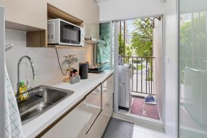 a kitchen with a sink and a balcony at Spacious 1BR wSofa Bed Pool Gym 1Gbps Wi-Fi in Kathu +43 photos