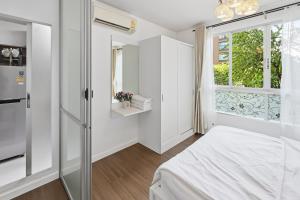 a small bedroom with a bed and a window at Spacious 1BR wSofa Bed Pool Gym 1Gbps Wi-Fi in Kathu