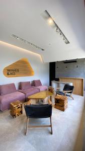 ein Wohnzimmer mit einem lila Sofa und Holztischen in der Unterkunft Waves & Ko in San Andrés
