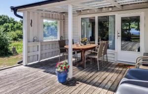 a screened in porch with a wooden table and chairs at 2 Bedroom Amazing Home In Jämjö in Torhamn