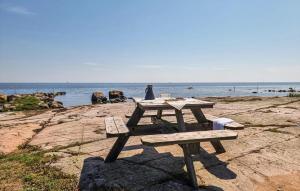 a picnic table sitting on the rocks near the water at 2 Bedroom Amazing Home In Jämjö in Torhamn