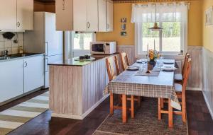 a kitchen with a table with chairs and a microwave at 2 Bedroom Amazing Home In Jämjö in Torhamn