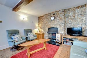 a living room with two chairs and a table and a tv at 3 Bed in Torquay oc-h75059 in Torquay
