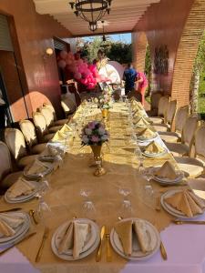 a long table with plates of food and wine glasses at Villa Maloulou in Marrakesh +55 photos