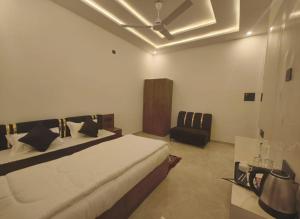 a bedroom with a bed and a black chair at Arohan stay in Ayodhya +40 photos
