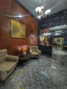 a lobby with chairs and a table and a mirror at Hotel y Hostal AH MUN in Mérida