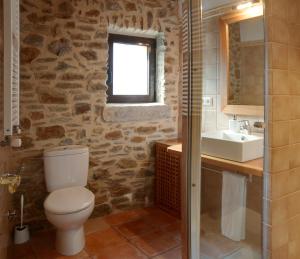 uma casa de banho com um WC, um lavatório e uma janela em Vilars 10 em Espolla