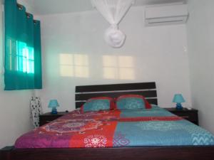 a bedroom with a bed with two pillows on it at Frédovacances logement iGloo-LOVE in Rivière-Pilote +21 photos