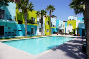 a swimming pool in front of a building with palm trees at Ocean View, Amazing Sunsets, AC, Pool in Tijuana