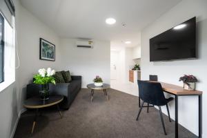 a living room with a couch and a table at Solsen Flexi-Stay & Motel in Auckland