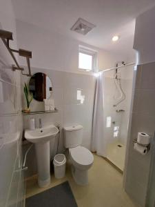a white bathroom with a toilet and a sink at Elisha's Guest House in Coron +56 photos