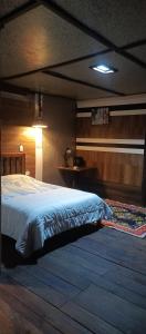 a bedroom with a large bed with a light on it at Raíces de Papallacta in Papallacta
