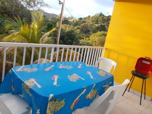a blue table and chairs on a balcony at Frédovacances logement iGloo-LOVE in Rivière-Pilote