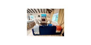 a living room with a blue couch and a table at Shared Space in SoSo Coastal Retreat in West Palm Beach