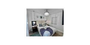 a bedroom with a bed with purple pillows at Shared Space in SoSo Coastal Retreat in West Palm Beach