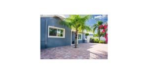 a house with a palm tree in the driveway at Shared Space in SoSo Coastal Retreat in West Palm Beach