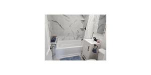 a bathroom with a white tub and a sink at Shared Space in SoSo Coastal Retreat in West Palm Beach +17 photos