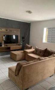a living room with two couches and a flat screen tv at Casa Aconchego do Cabrobó in Piranhas