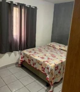 a bedroom with a bed with a flowered blanket at Casa Aconchego do Cabrobó in Piranhas