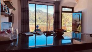 a man sitting in a room looking out a large window at a pool at HAPUTHALE Ceylon shadow in Haputale