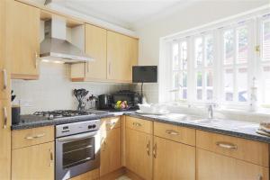 a kitchen with wooden cabinets and a sink and a stove at 3 Bed in Southwold oc-kit in Reydon