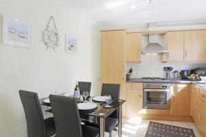 a kitchen with a table and chairs and a kitchen with a stove at 3 Bed in Southwold oc-kit in Reydon +7 photos