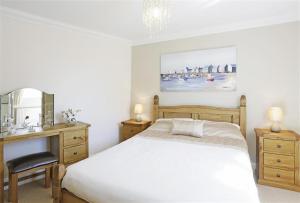 a bedroom with a bed and a desk and a mirror at 3 Bed in Southwold oc-kit in Reydon