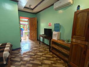 a room with a bed and a desk with a television at Little Apple Inn in San Juan