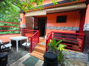 a house with a red fence and a table on a porch at Little Apple Inn in San Juan +2 photos