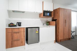 a kitchen with a refrigerator and a microwave at Solsen Flexi-Stay & Motel in Auckland