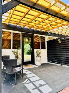 a patio with a black door and a wooden pergola at Studio Vellae in Corinthe