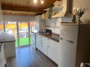 a kitchen with a white refrigerator and a sink at Ático El Hub in León +10 photos