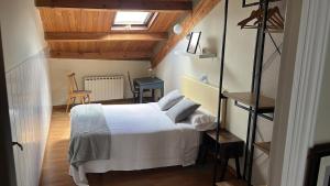 a bedroom with a white bed and a window at Ático El Hub in León