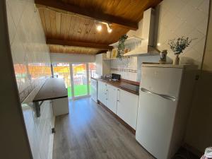 a kitchen with a white refrigerator and a wooden floor at Ático El Hub in León