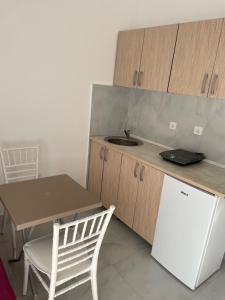 a kitchen with a table and a sink and a refrigerator at Apartments Budva Sunset in Budva +36 photos