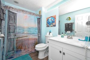 a bathroom with a toilet and a shower curtain at Cedar Key Islands Dolphins Cay Condo in Cedar Key +21 photos