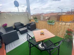 a patio with a table and chairs on a balcony at Ático El Hub in León
