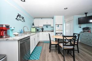 a kitchen with white cabinets and a table and chairs at Cedar Key Islands Dolphins Cay Condo in Cedar Key