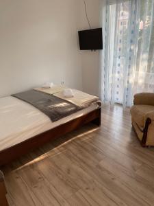 a bedroom with a large bed and a chair at Apartments Budva Sunset in Budva