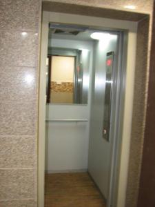 a hallway with a door and a mirror at Hotel Confirm Inn Kota in Kota +3 photos