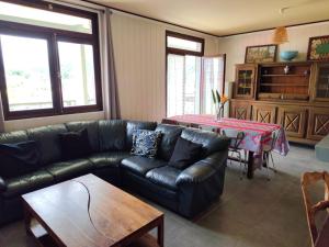 a living room with a leather couch and a table at La villa Madelon in Cilaos