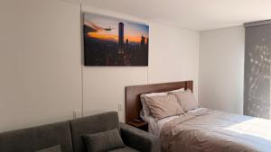 a bedroom with a bed and a couch and a picture at Teusaquillo Urban Loft in Bogotá