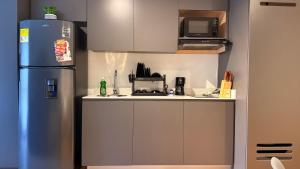 a small kitchen with a refrigerator and a microwave at Teusaquillo Urban Loft in Bogotá
