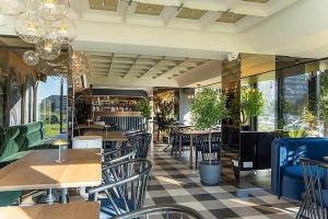 a restaurant with tables and chairs and windows at Casa MIO in Braşov