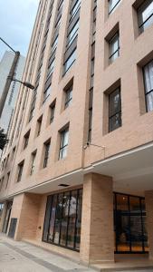 a large brick building with windows on a street at Teusaquillo Urban Loft in Bogotá