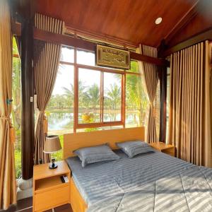 a bedroom with a bed and a large window at Melalueca tây ninh in Tây Ninh +45 photos