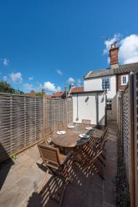 a patio with a wooden table and chairs on a fence at 2 Bed in Southwold oc-twi2 in Southwold