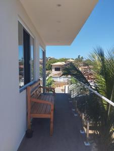a porch with a bench and a view of the beach at 05 minutos da praia - Casa Superior céu azul Buzios in Búzios