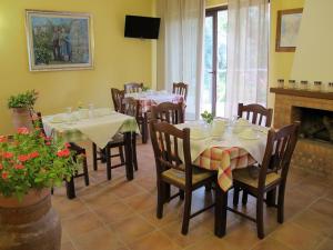 comedor con mesas y sillas y chimenea en Stella Di Sicilia, en San Fratello